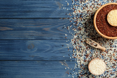Flat lay composition with brown and other types of rice on color wooden background. Space for textの写真素材