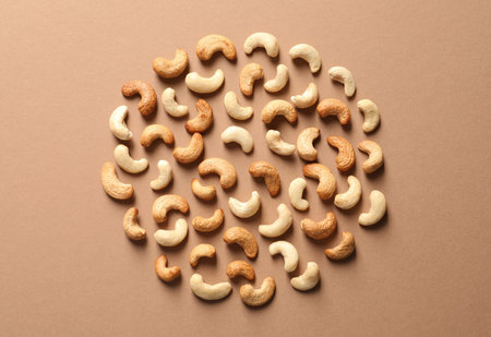 Tasty cashew nuts on color background, flat lay