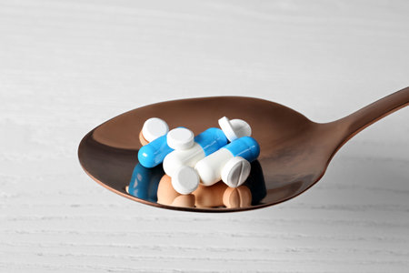 Spoon with weight loss pills on light backgroundの写真素材