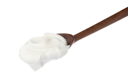 Wooden spoon with sour cream on white backgroundの写真素材