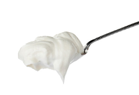 Metal spoon with sour cream on white backgroundの写真素材