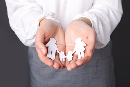 Woman holding cutout paper family, closeup. life insurance conceptの写真素材