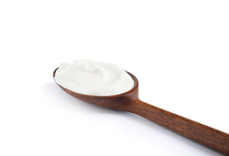 Wooden spoon with sour cream on white backgroundの写真素材