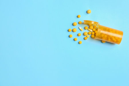 Flat lay composition with bottle, pills and space for text on color backgroundの写真素材