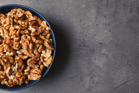 Dish with walnuts on gray background, top view. Space for textの写真素材