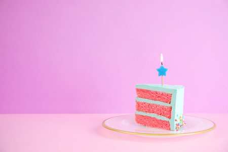 Slice of fresh delicious birthday cake with candle on table against color background. Space for text