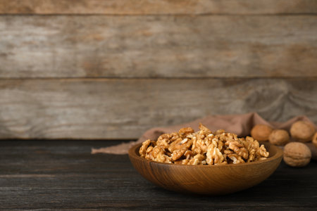 Dish with walnuts on wooden table. Space for textの写真素材