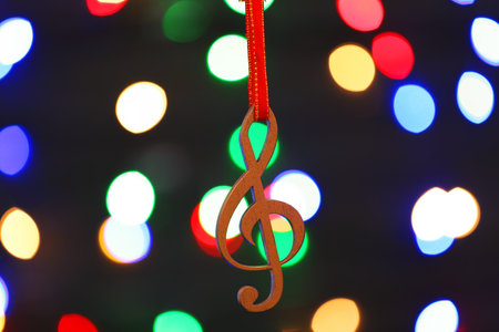 Wooden treble clef against blurred lights. christmas musicの写真素材