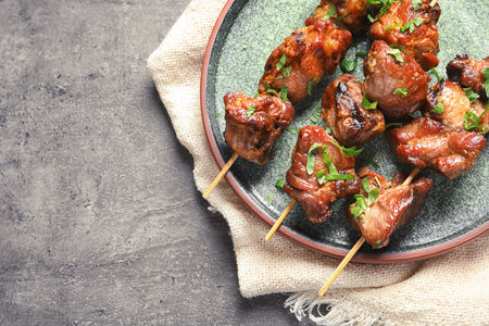 Plate of delicious barbecued meat on gray background, top view. Space for textの写真素材