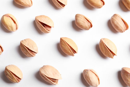 Organic pistachio nuts on white background, flat lay