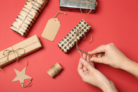 Woman decorating gift box on color background, top viewの写真素材