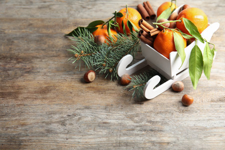 Christmas composition with toy sleigh, ripe tangerines and space for text on wooden tableの写真素材