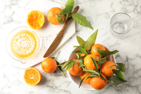 Flat lay composition with ripe tangerines and juicer on marble backgroundの写真素材