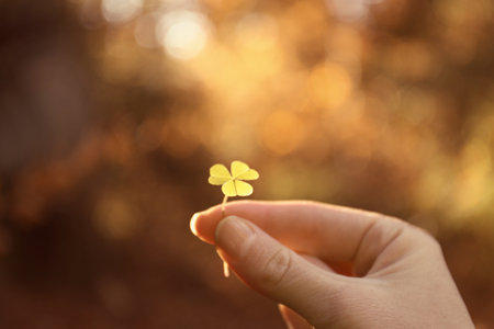 Woman holding green clover in autumn forest