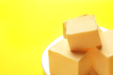 Plate with fresh butter on color background, closeup. Space for textの写真素材