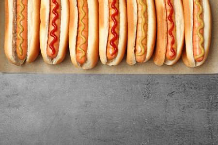 Tasty fresh hot dogs on gray background, top view. Space for textの写真素材