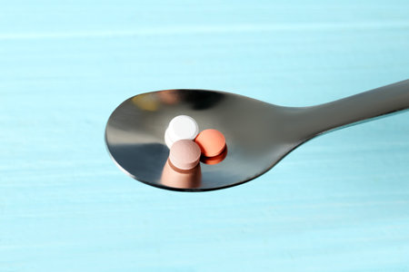 Spoon with weight loss pills on color backgroundの写真素材