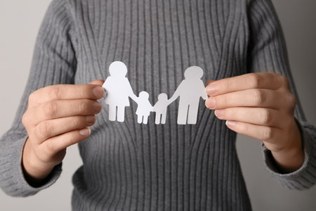 Woman holding paper silhouette of family, closeup. life insurance conceptの写真素材