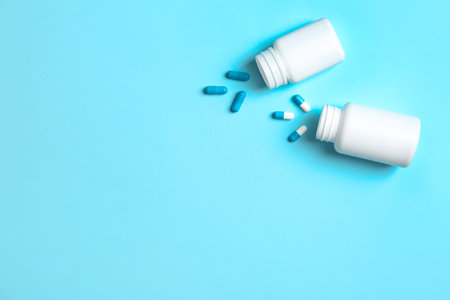 Flat lay composition with bottles, pills and space for text on color backgroundの写真素材