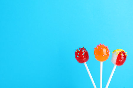Bright yummy candies on color background. Space for text