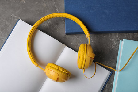 Modern headphones with hardcover books on gray background, top viewの写真素材