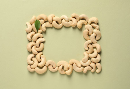 Frame made with tasty cashew nuts on color background, top view. Space for textの写真素材