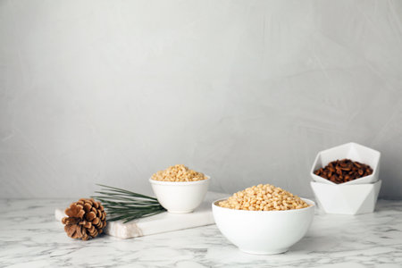Bowl with pine nuts on table. Space for text