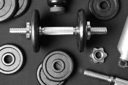 Flat lay composition with dumbbell and parts on dark backgroundの写真素材