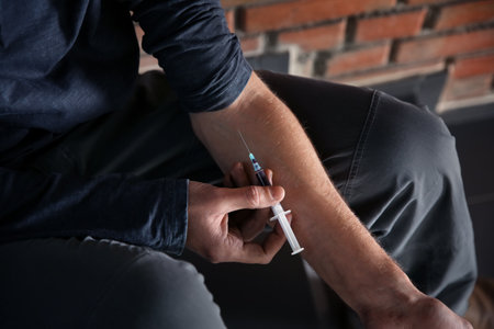 Male drug addict making injection, closeup of handsの写真素材