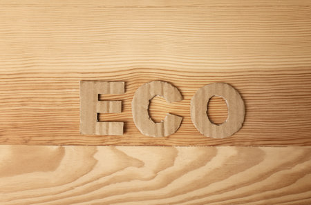 Word "Eco" made of cardboard letters on wooden background, top viewの写真素材