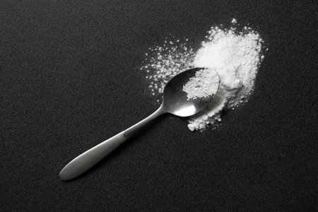 Spoon and cocaine powder on dark background, top viewの写真素材