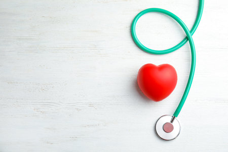 Stethoscope and red heart on wooden background, top view with space for text. cardiology conceptの写真素材