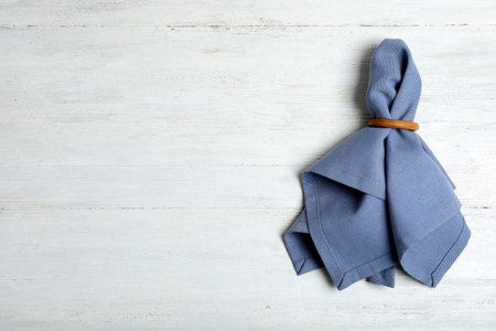Fabric table napkin with decorative ring and space for text on wooden background, top viewの写真素材