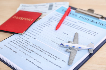 Composition with toy plane and travel insurance form on tableの写真素材