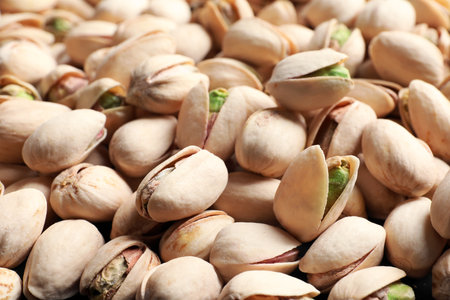 Organic pistachio nuts in shell as background, closeupの写真素材