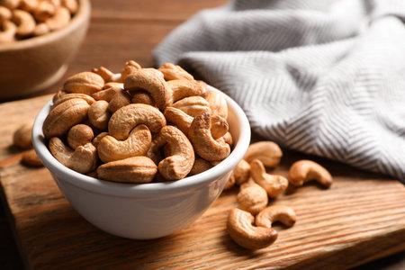Tasty cashew nuts in bowl on tableの写真素材