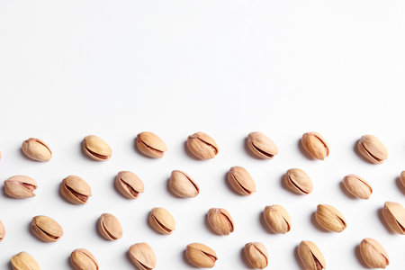 Organic pistachio nuts on white background, flat lay. Space for textの写真素材