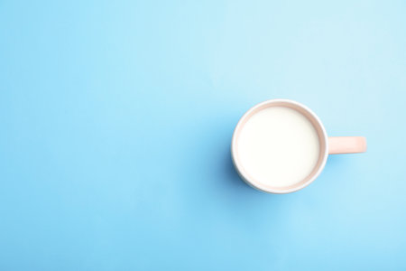 Cup of fresh milk on color background, top view. Space for textの写真素材