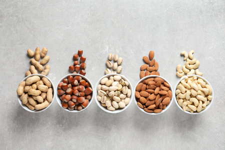 Flat lay composition with organic nuts on gray background, top view. snack mixの写真素材