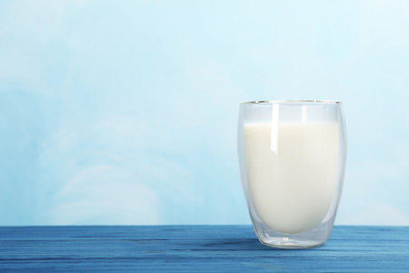 Glass with fresh milk on table against color background. Space for textの写真素材