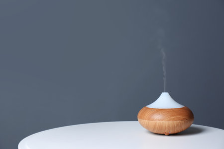 Aroma oil diffuser lamp on table against gray background. Space for textの写真素材