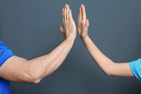 Man and woman giving high five on color backgroundの写真素材