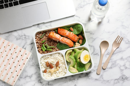 Flat lay composition with container of natural protein food on office tableの写真素材