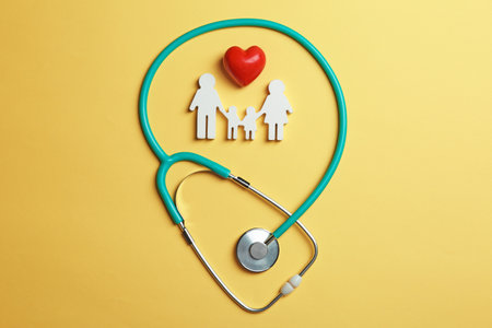 Flat lay composition with heart, stethoscope and family figure on color background. life insurance conceptの写真素材