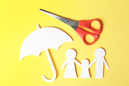 Paper silhouettes of family with umbrella and scissors on color background, flat lay. life insurance conceptの写真素材