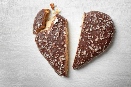 Broken heart shaped cookie on gray background, top view. relationship problems