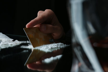 Drug addict taking cocaine at table, closeup viewの写真素材