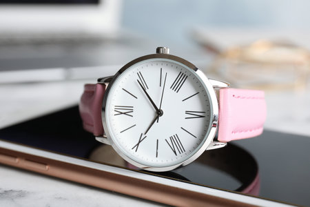 Stylish wrist watch with modern smartphone on marble table. fashion accessoriesの写真素材