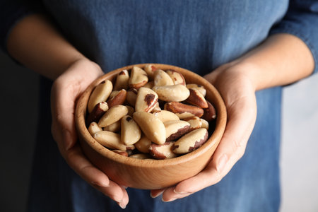 Woman holding bowl with brazil nuts, closeupの写真素材