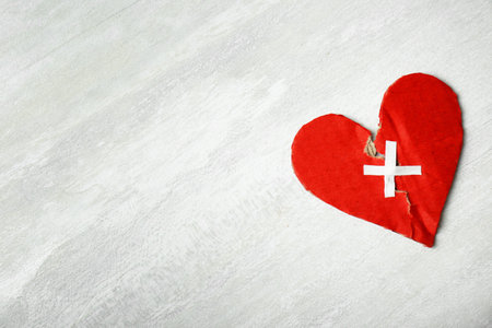 Torn cardboard heart joined with adhesive plasters on gray background. relationship problemsの写真素材